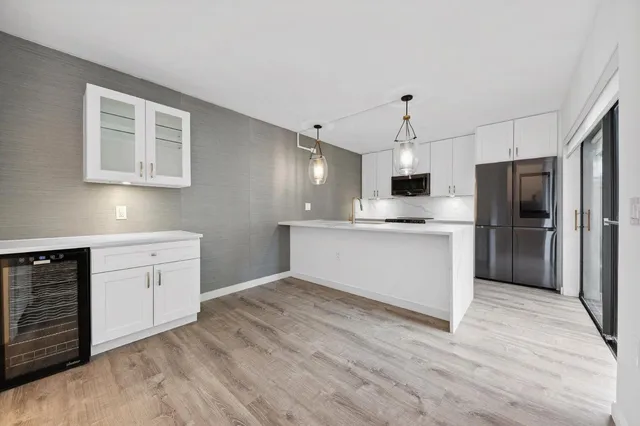 a kitchen with a refrigerator and white cabinets
