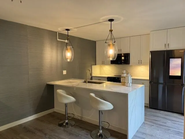 a kitchen with kitchen island a counter space a sink appliances and cabinets