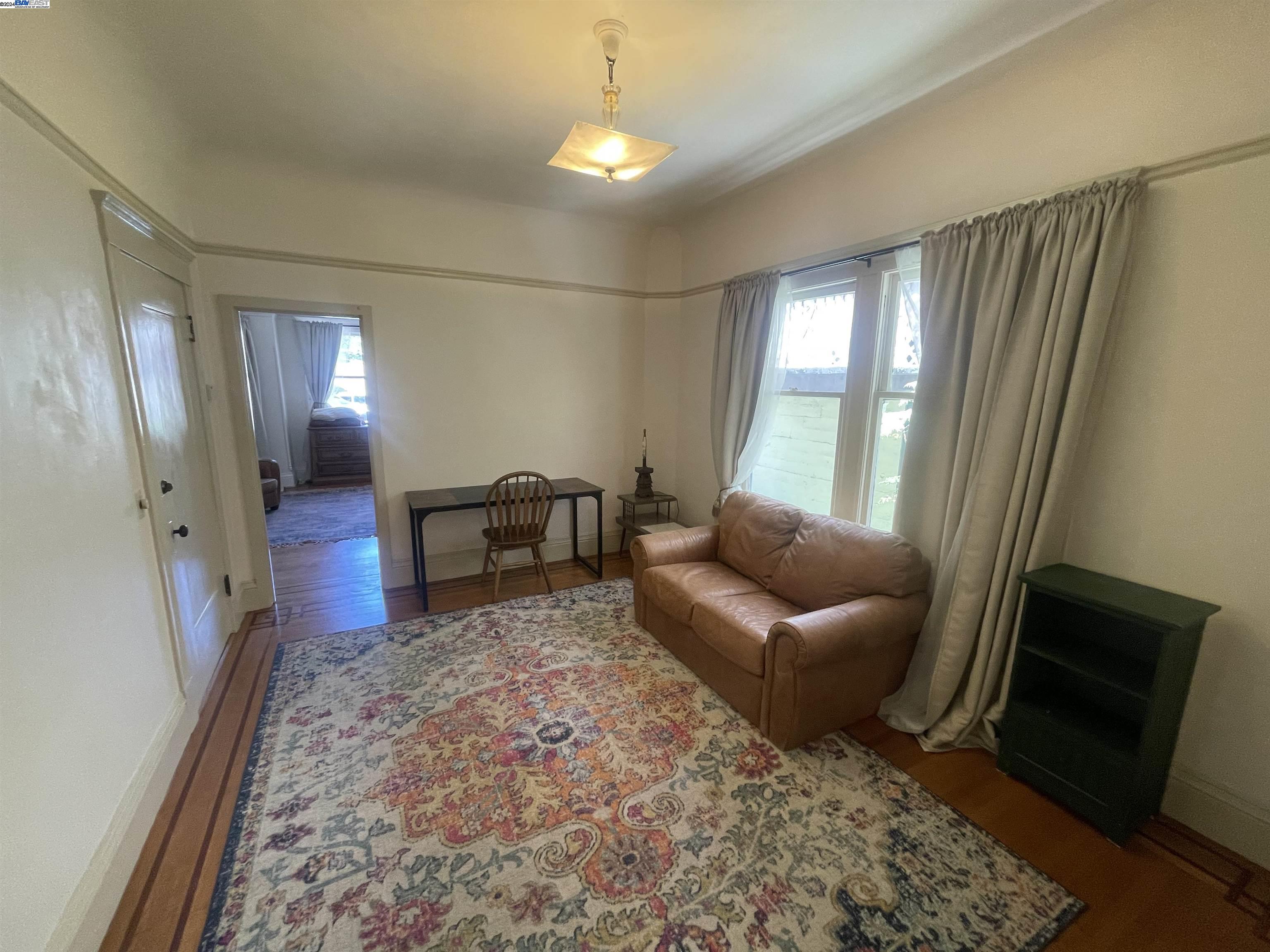Adams Point Oakland, CA 94610 - Photo 11 of 16 a living room with furniture and a rug