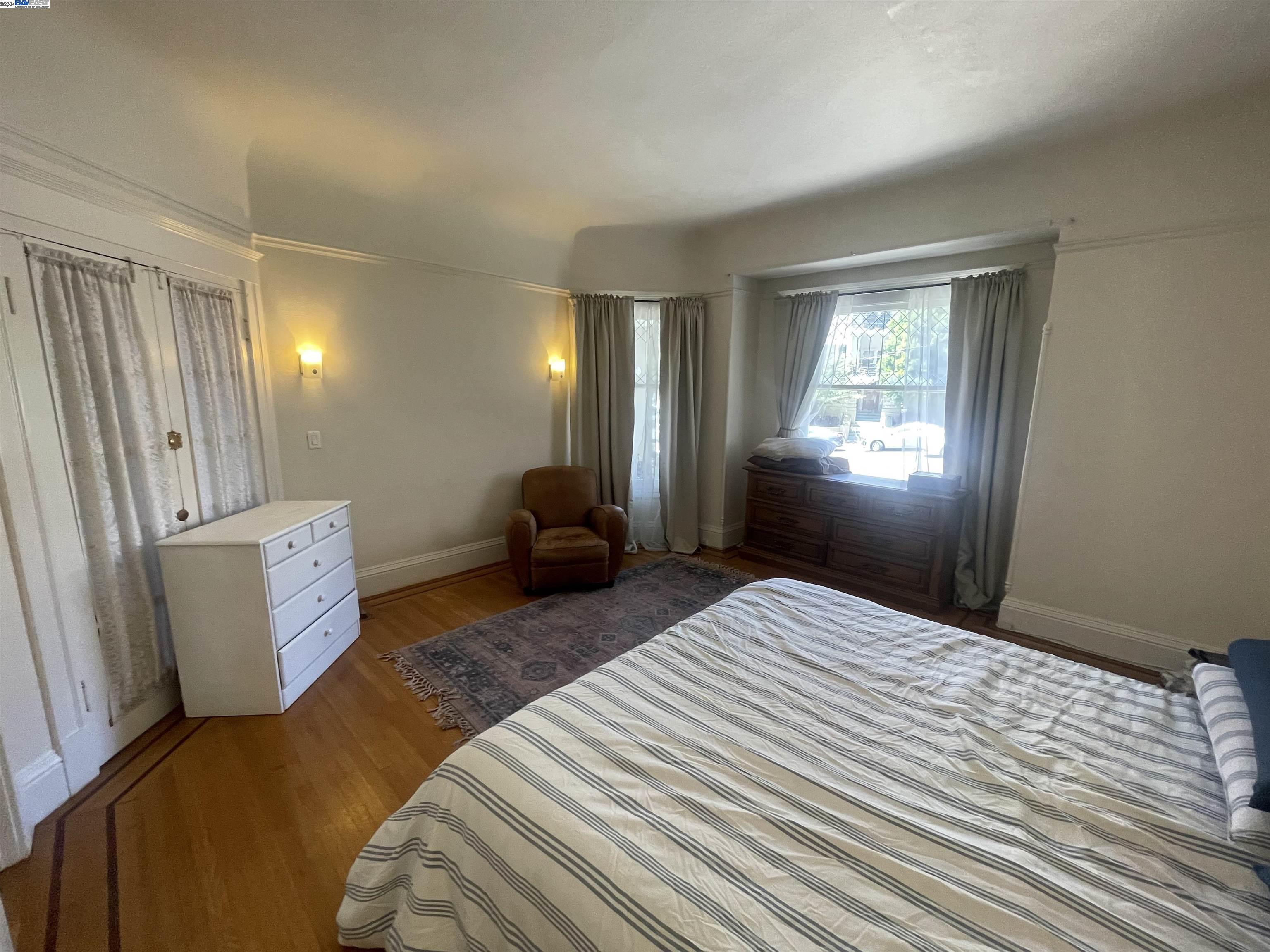 Adams Point Oakland, CA 94610 - Photo 13 of 16 a bedroom with a bed and wooden floor