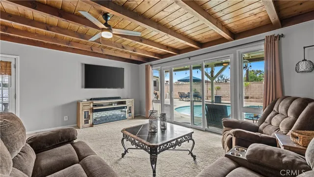 a living room with furniture a flat screen tv and a large window
