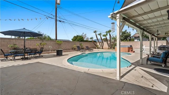 a view of a patio with table and chairs under an umbrella