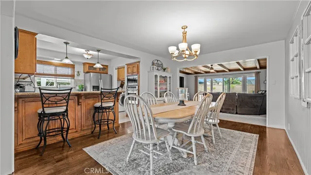 a view of a dining room with furniture a chandelier and wooden floor