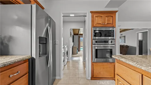 a kitchen with stainless steel appliances granite countertop a refrigerator and a stove top oven