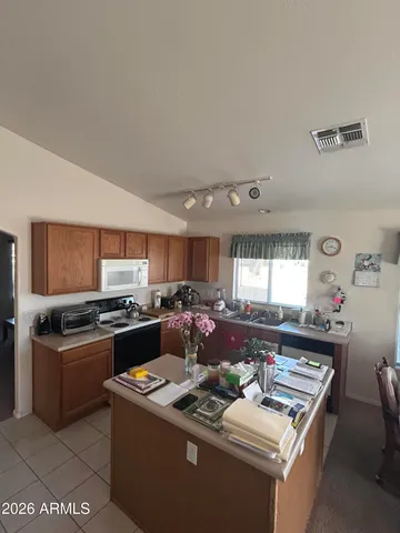 a kitchen with stainless steel appliances kitchen island granite countertop a sink dishwasher stove top oven and cabinets