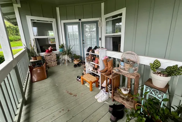 a view of a dining room with furniture one side kitchen view and wooden floor