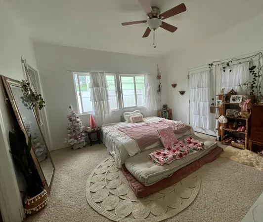 a bedroom with a bed and a flat tv screen on the dresser