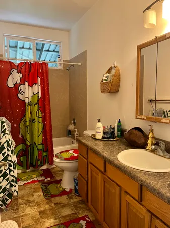 a bathroom with a granite countertop sink mirror vanity and toilet