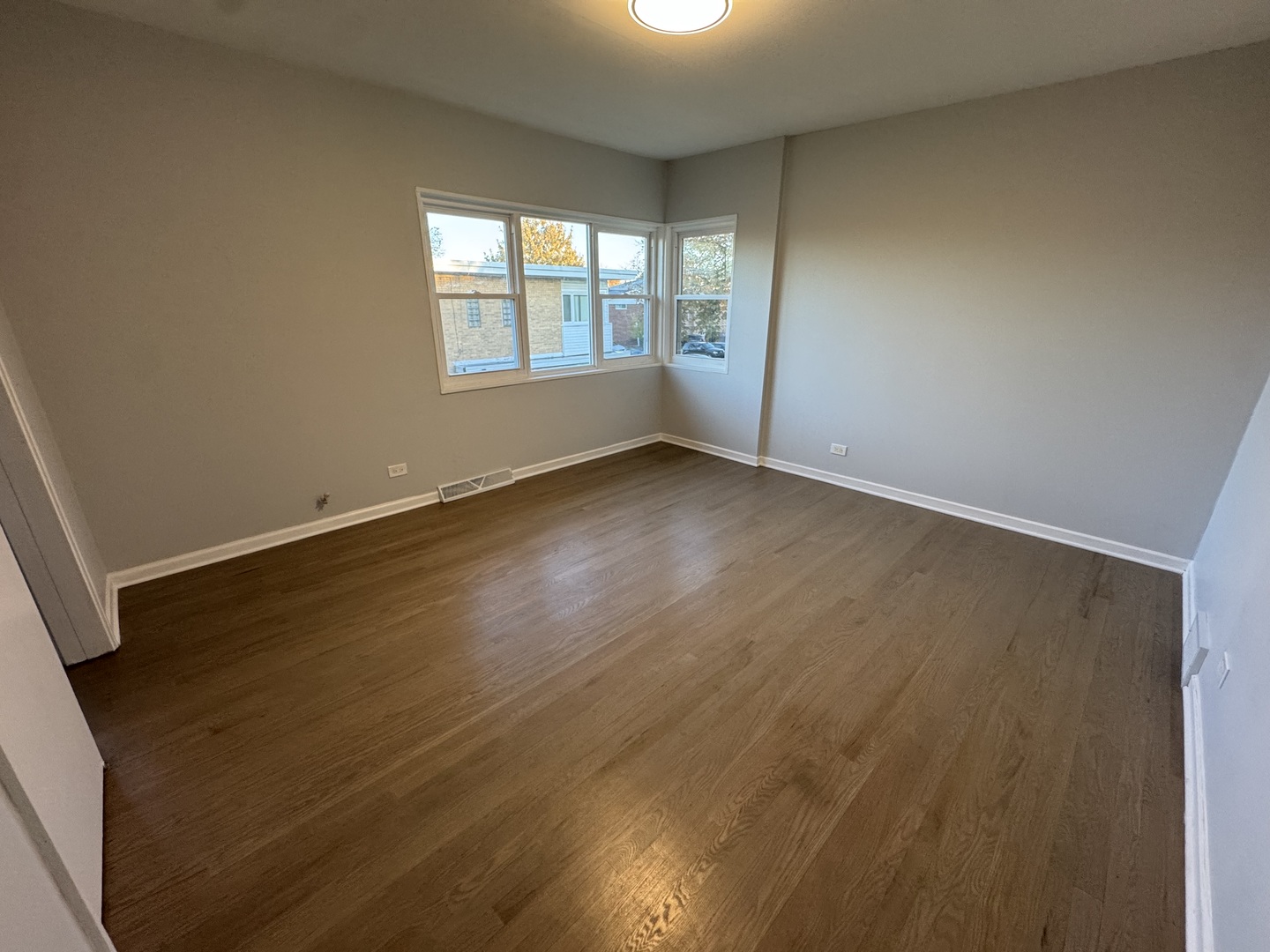 4912 Crain Street, Unit C Skokie, IL 60077 - Photo 11 of 15 an empty room with wooden floor and windows