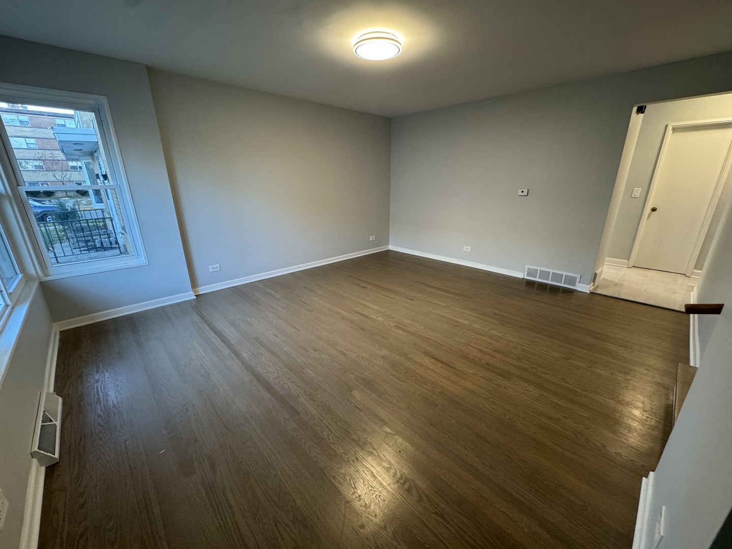 4912 Crain Street, Unit C Skokie, IL 60077 - Photo 3 of 15 an empty room with wooden floor and windows