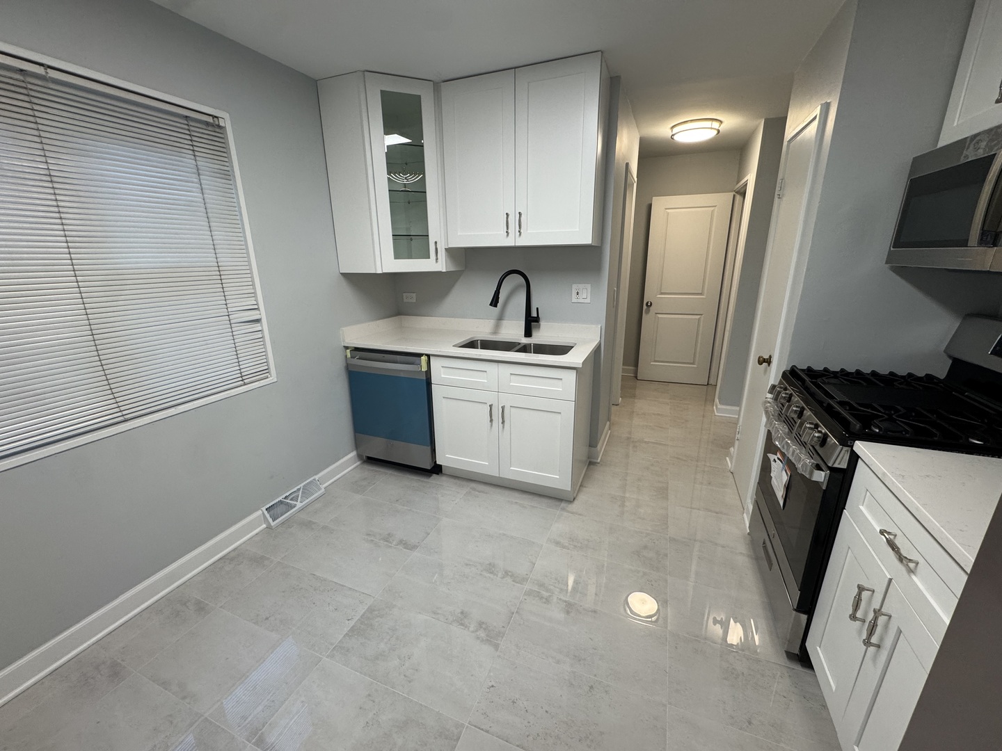 4912 Crain Street, Unit C Skokie, IL 60077 - Photo 6 of 15 a kitchen with granite countertop a sink stove and refrigerator