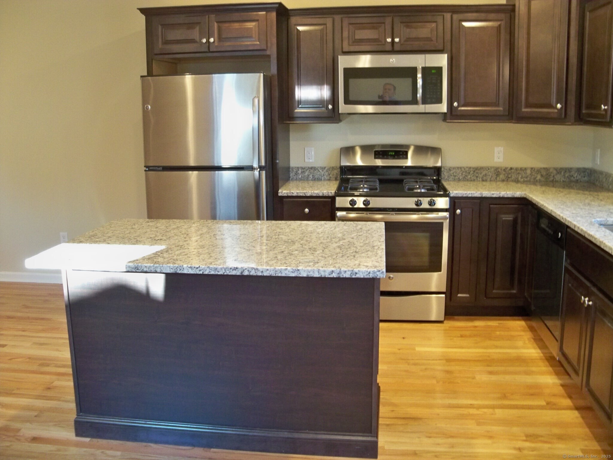 404 Main Street, Unit 13 Wallingford, CT 06492 - Photo 3 of 19 a kitchen with stainless steel appliances granite countertop a stove a refrigerator and a microwave oven