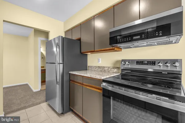 a kitchen with stainless steel appliances granite countertop a refrigerator and a stove
