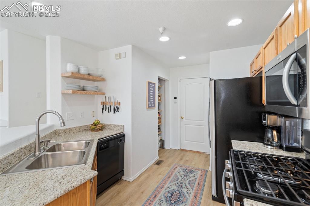 3231 Apogee View Colorado Springs, CO 80906 - Photo 15 of 38 a kitchen with stainless steel appliances granite countertop a sink stove and refrigerator