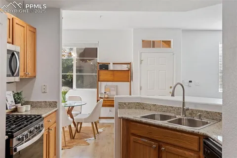 a kitchen with granite countertop a sink and a stove top oven