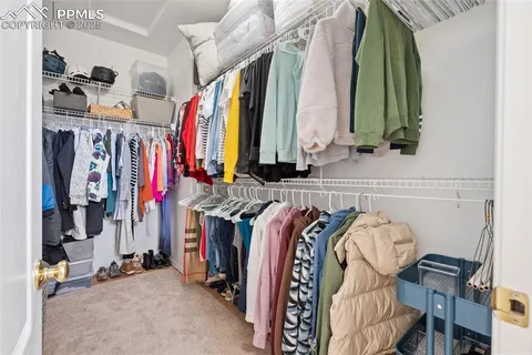 a view of walk in closet with clothes and shoes