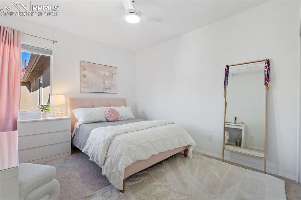 3231 Apogee View Colorado Springs, CO 80906 - Photo 30 of 38 a bedroom with a bed and a painting on the wall