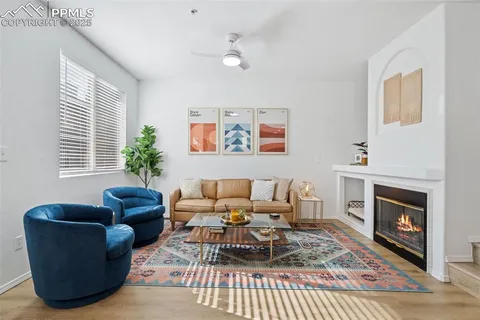 a living room with furniture a rug a fireplace and a window