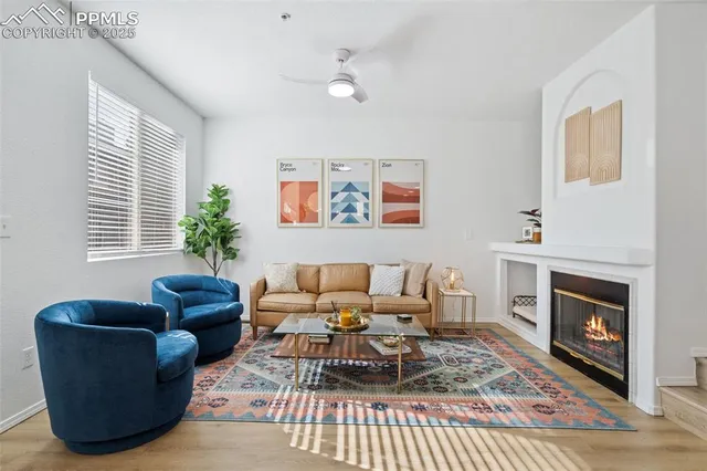 a living room with furniture a rug a fireplace and a window