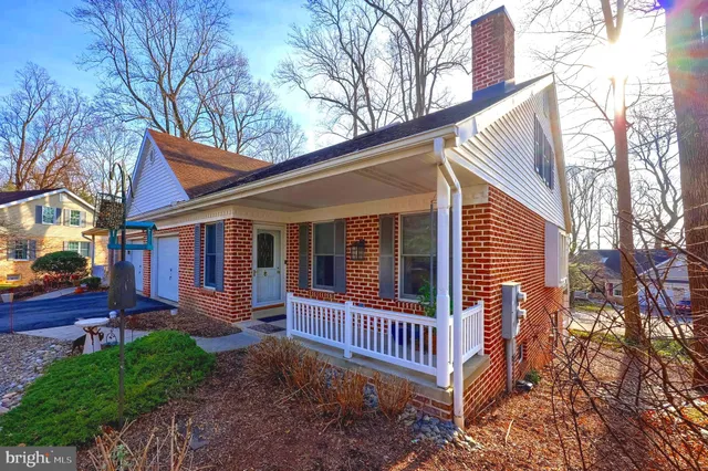 a view of a house with a yard and large tree