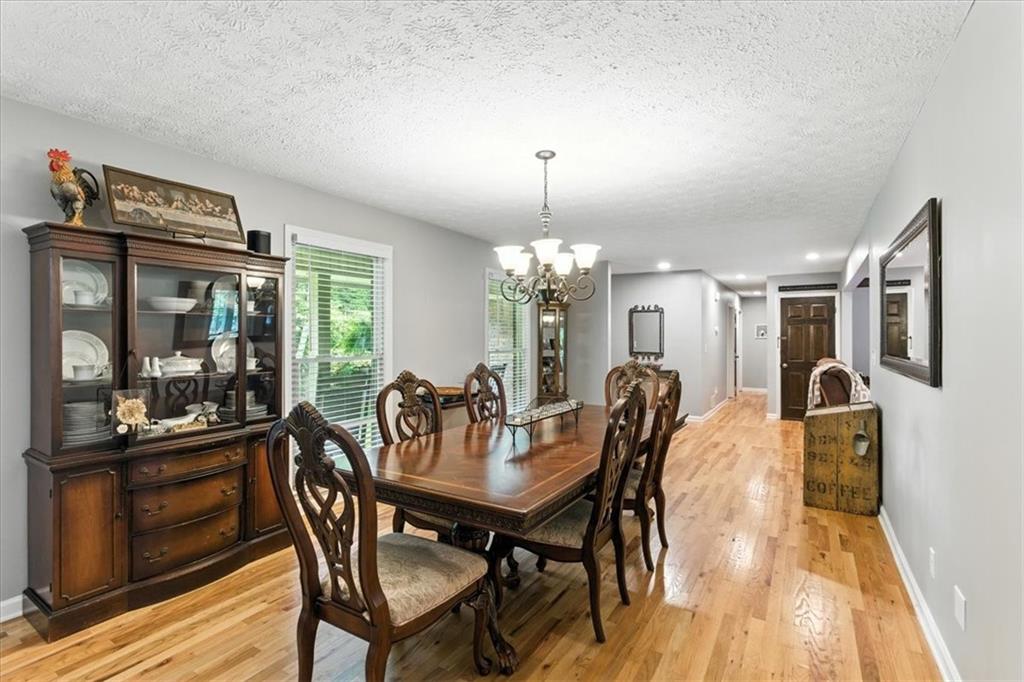 4970 Nebo Road Hiram, GA 30141 - Photo 13 of 61 a dining room with furniture a chandelier and wooden floor