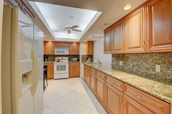 a kitchen with granite countertop a stove sink and cabinets