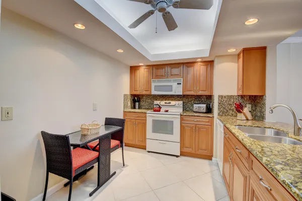 a kitchen with granite countertop a sink and white cabinets