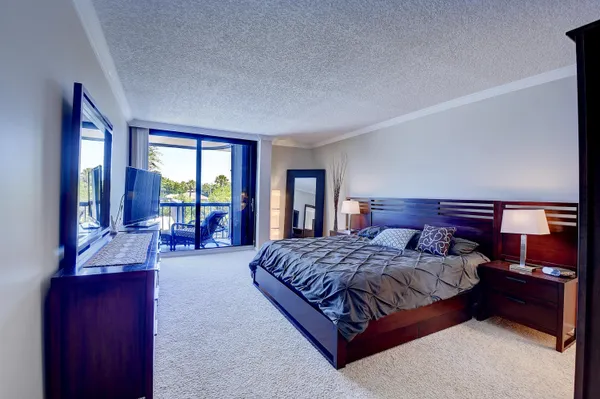 a bedroom with a large bed and a flat tv screen on dresser