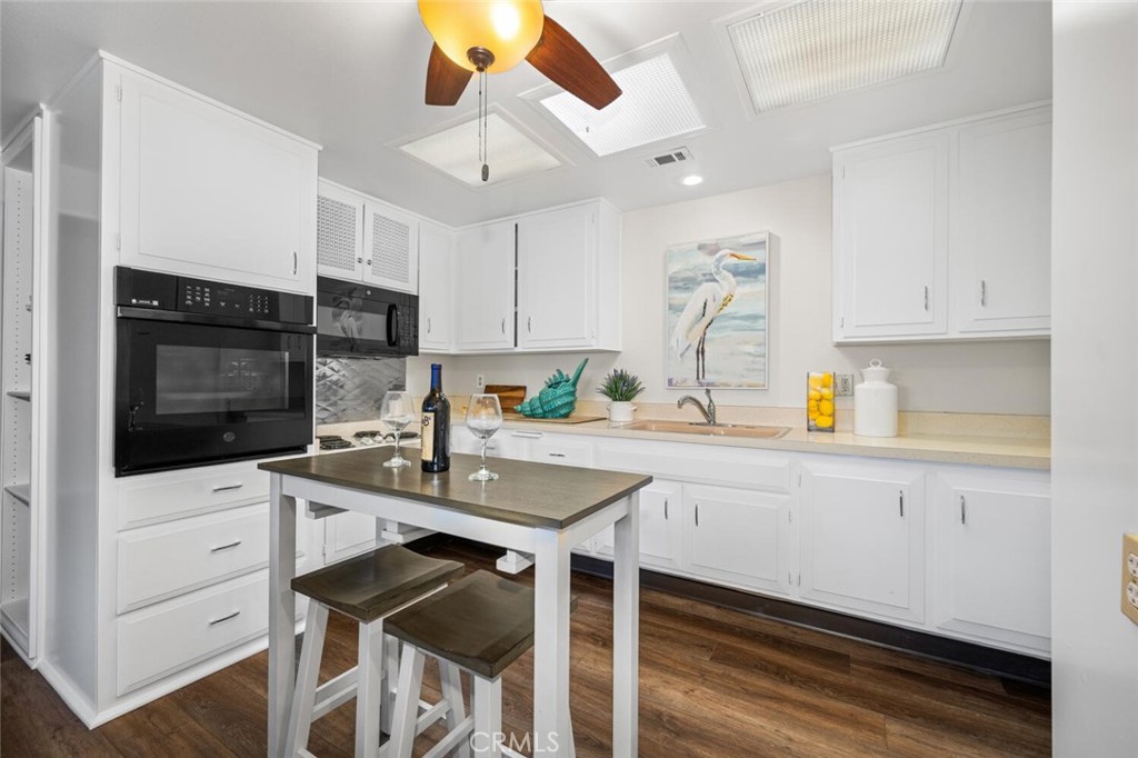 1621 Interlachen Road, Unit 265B Seal Beach, CA 90740 - Photo 21 of 36 a kitchen with granite countertop a sink stainless steel appliances and white cabinets