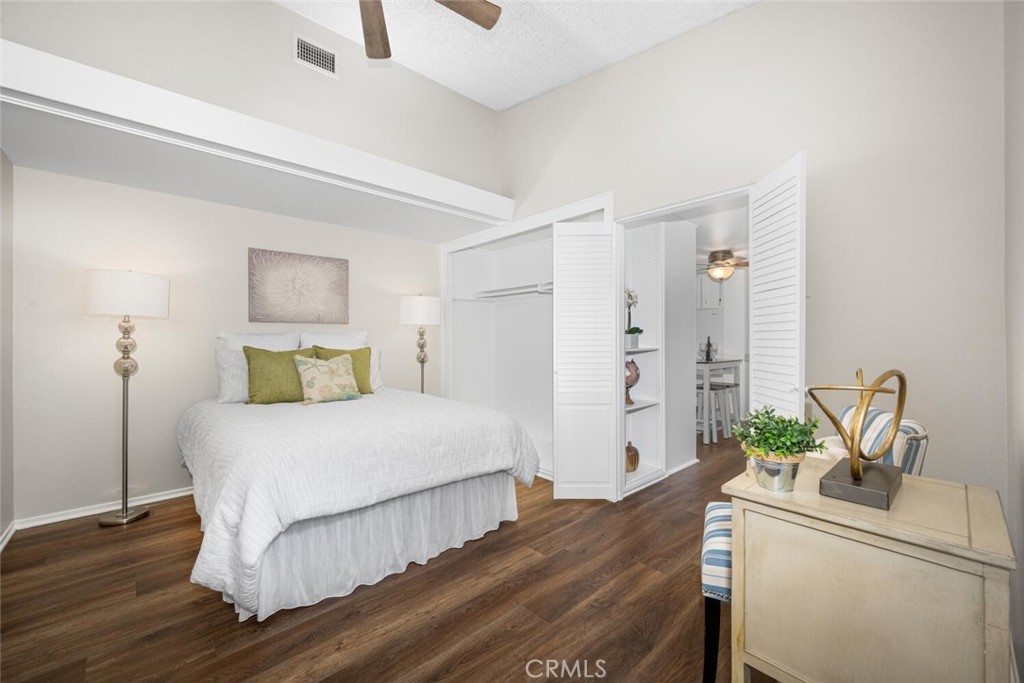 1621 Interlachen Road, Unit 265B Seal Beach, CA 90740 - Photo 28 of 36 a bedroom with a bed and a dresser with wooden floor