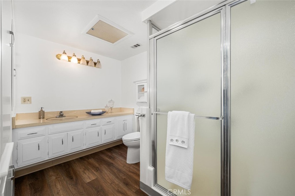 1621 Interlachen Road, Unit 265B Seal Beach, CA 90740 - Photo 31 of 36 a bathroom with a granite countertop sink toilet a large mirror a shower and vanity