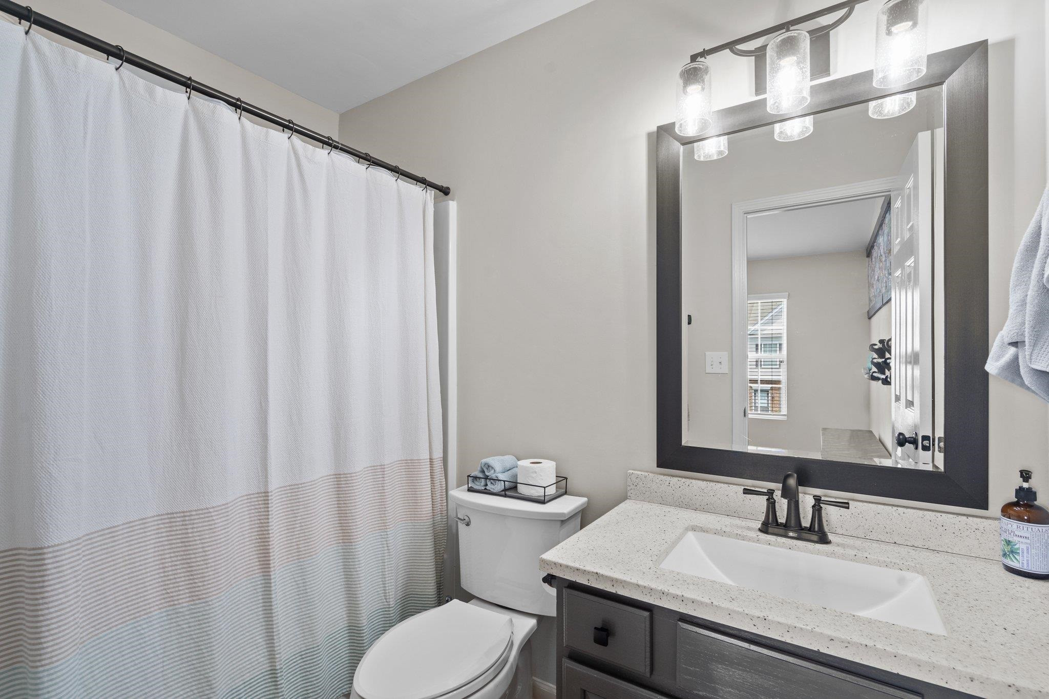 1750 Sorrell Brook Way Raleigh, NC 27609 - Photo 27 of 32 a bathroom with a sink a toilet and shower curtain