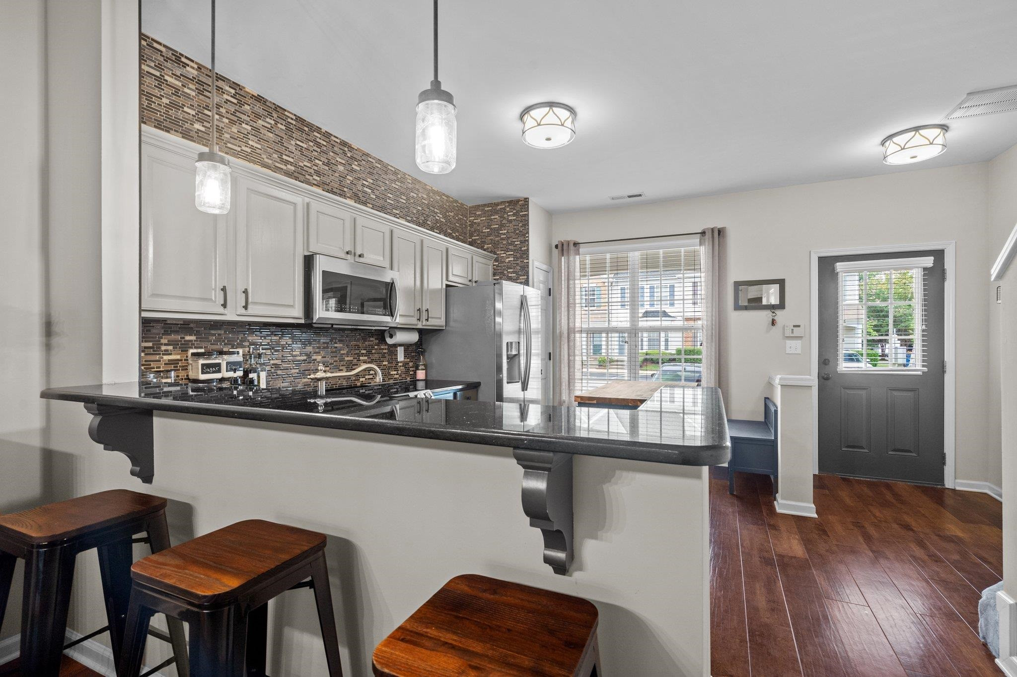 1750 Sorrell Brook Way Raleigh, NC 27609 - Photo 9 of 32 a kitchen with stainless steel appliances granite countertop a refrigerator a stove microwave cabinets and chairs