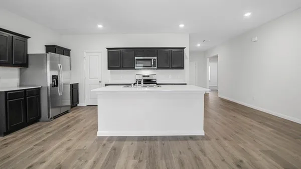 a kitchen with stainless steel appliances granite countertop a sink a microwave a refrigerator and a stove