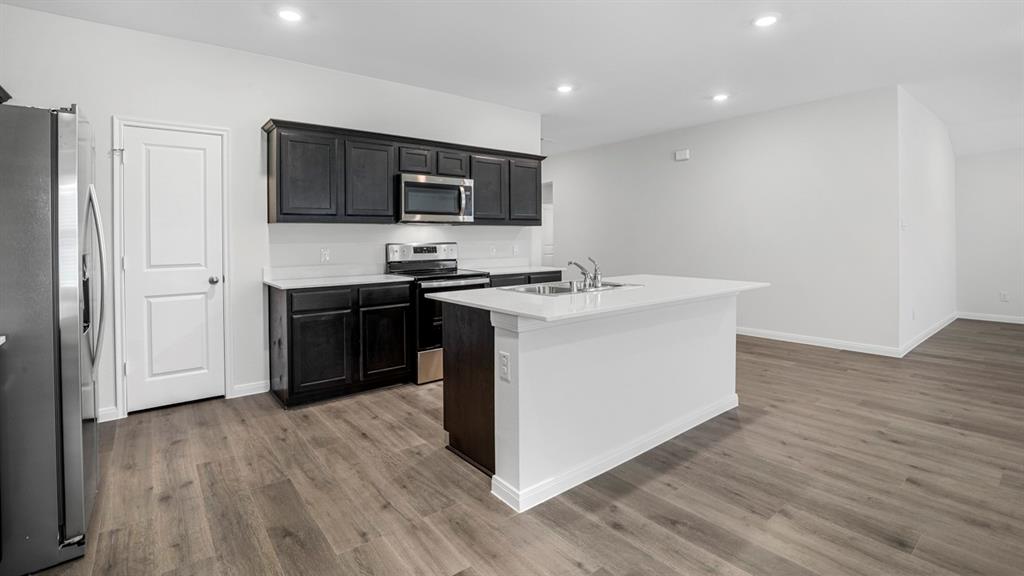 1921 Reveille Way Terrell, TX 75160 - Photo 16 of 25 a kitchen with stainless steel appliances a sink a stove top oven a wooden floor