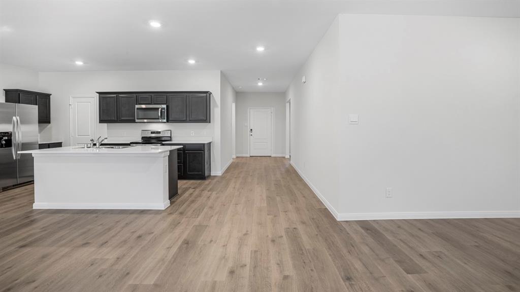 1921 Reveille Way Terrell, TX 75160 - Photo 25 of 25 a kitchen with stainless steel appliances a microwave a stove a sink dishwasher and a microwave with wooden floor