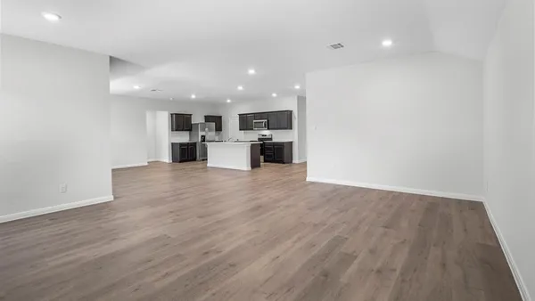 a view of kitchen with stainless steel appliances granite countertop a refrigerator and a stove top oven