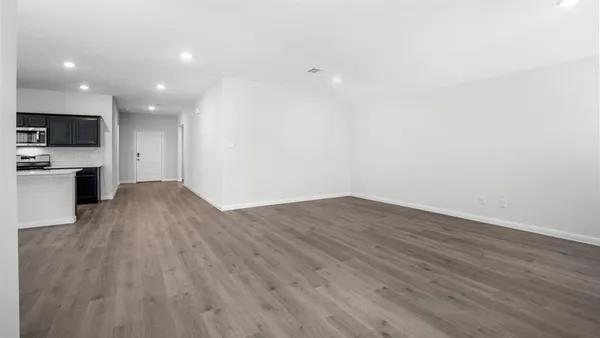 a kitchen with stainless steel appliances a microwave a stove a sink dishwasher and a microwave with wooden floor