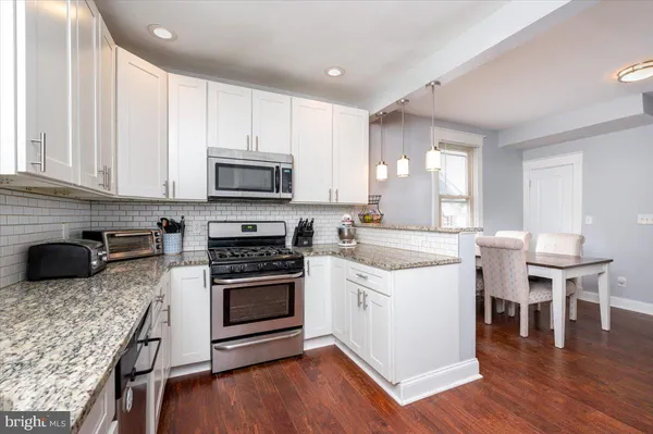 a kitchen with a stove a sink and a microwave
