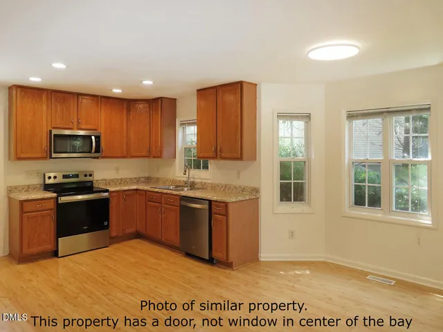 a large kitchen with granite countertop a stove a sink and a microwave