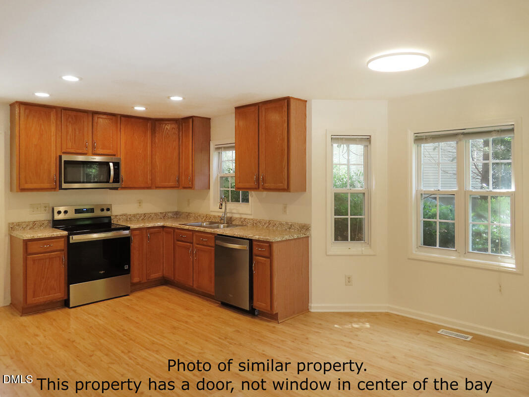 300 Davie Road Carrboro, NC 27510 - Photo 7 of 16 a large kitchen with granite countertop a stove a sink and a microwave