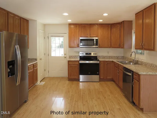 a kitchen with stainless steel appliances granite countertop a stove a sink dishwasher a refrigerator and a microwave