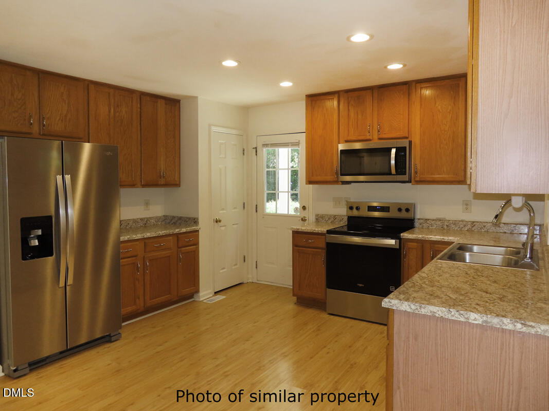 300 Davie Road Carrboro, NC 27510 - Photo 9 of 16 a kitchen with granite countertop a refrigerator and a stove top oven