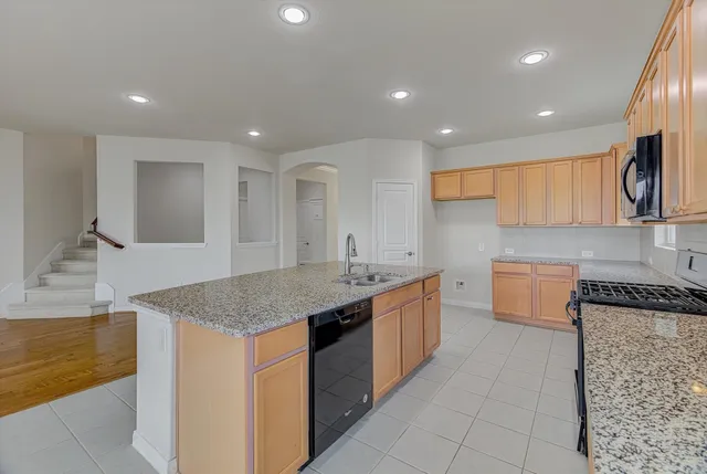 a bathroom with a granite countertop toilet a sink and a mirror