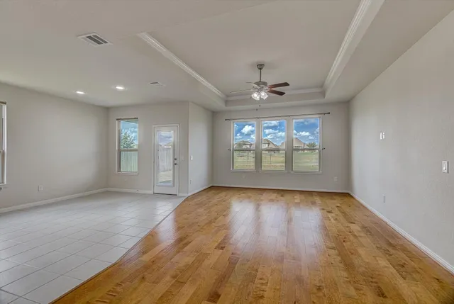 a view of a hallway with wooden floor and a kitchen space with a sink