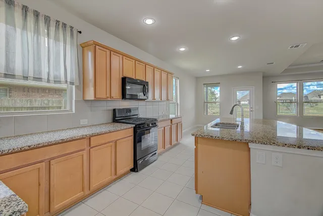 a kitchen with stainless steel appliances granite countertop a large counter top and a stove
