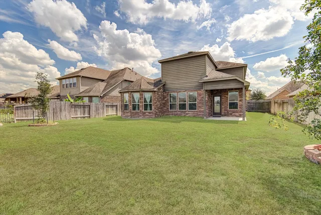 a view of a house with a big yard and large trees