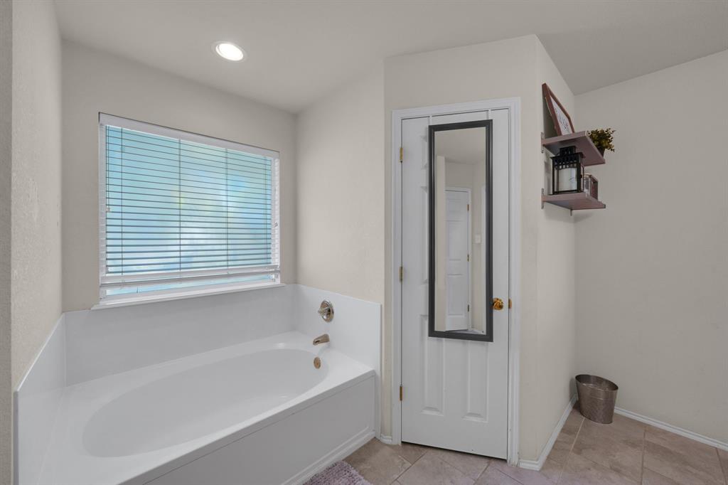 951 Behrens Court Crowley, TX 76036 - Photo 11 of 37 a bathroom with a bathtub and a shower