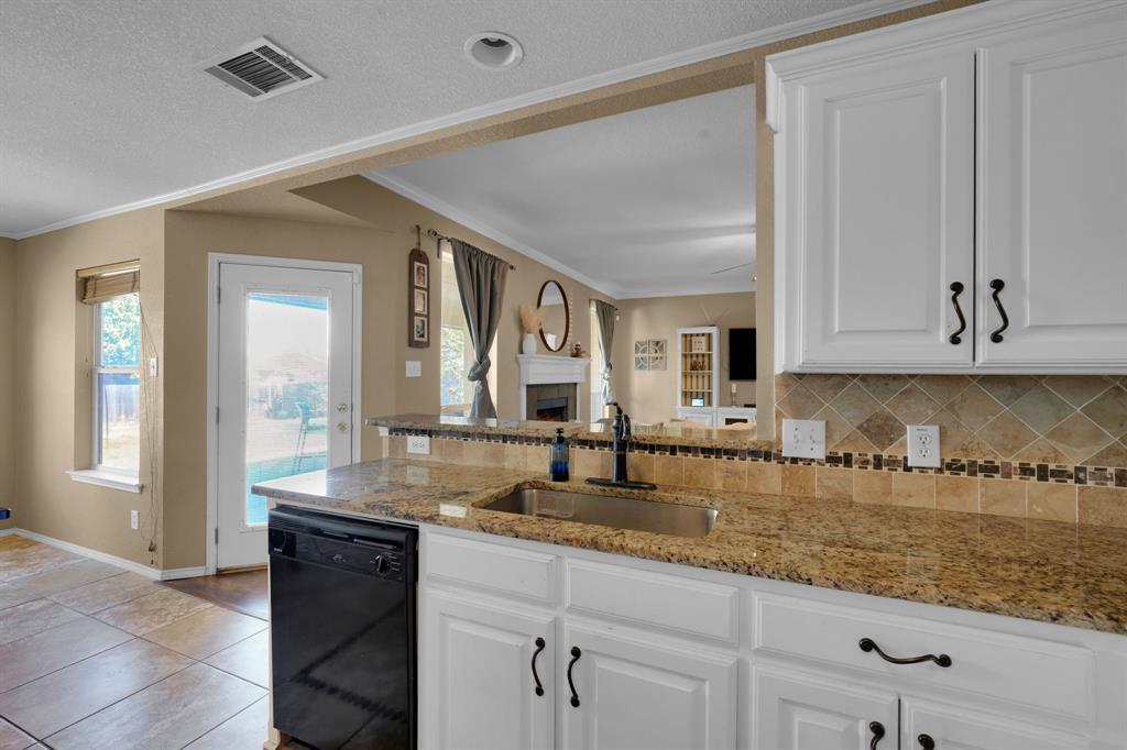 951 Behrens Court Crowley, TX 76036 - Photo 14 of 37 a kitchen with granite countertop a sink and cabinets