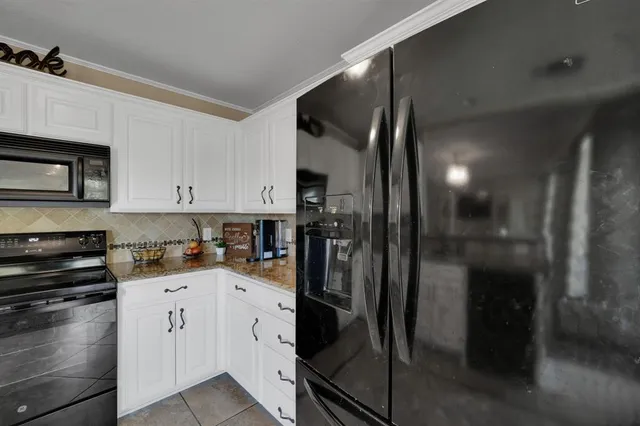 a kitchen with a refrigerator and a stove top oven